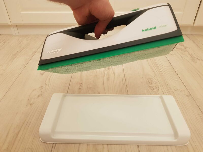 Der Vorwerk VG100 wird von seiner Unterstellplatte angehoben.